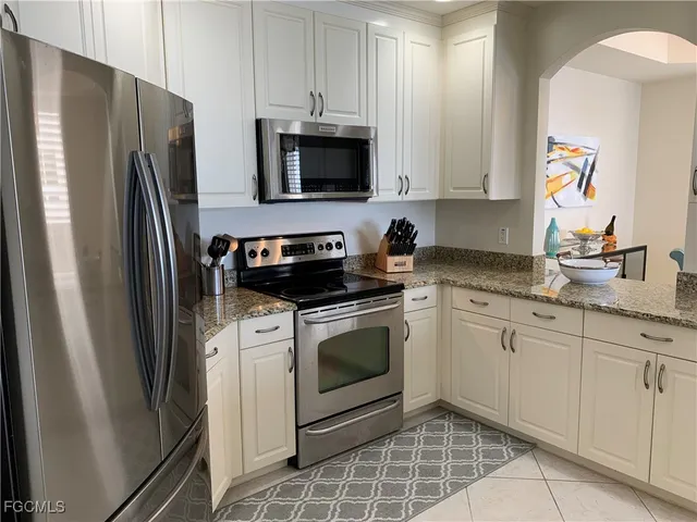 a kitchen with stainless steel appliances white cabinets a sink and a stove