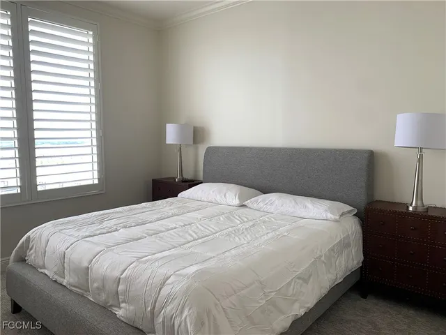 a large bed sitting in a bedroom next to a lamp and a lamp