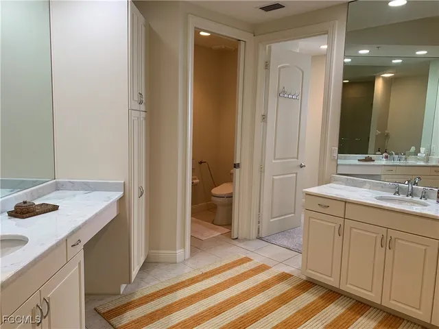 a spacious bathroom with a granite countertop sink a toilet and a mirror