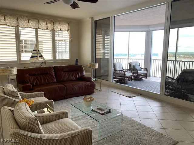 a living room with furniture and a floor to ceiling window