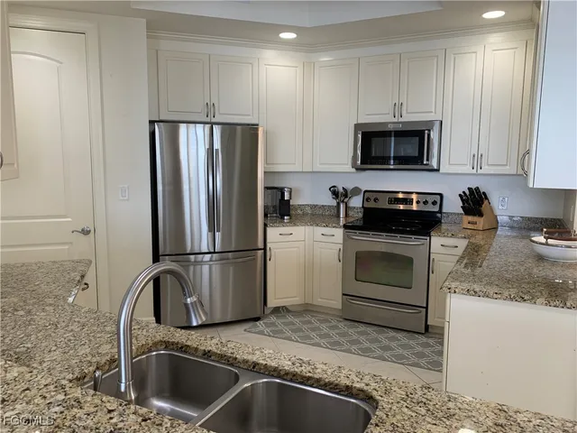a kitchen with white cabinets and stainless steel appliances