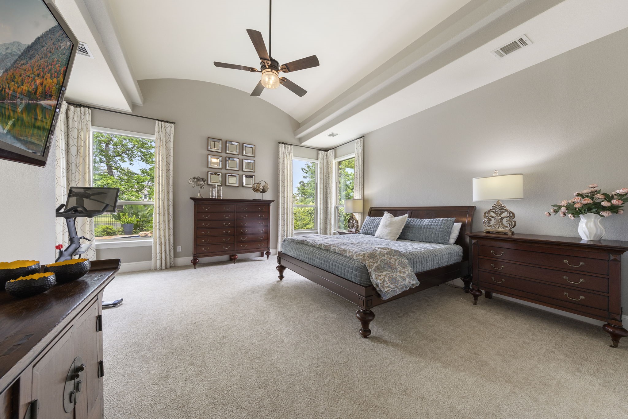 22 Marin Creek Place Spring, TX 77389 - Photo 14 of 38 Luxurious primary suite with tray ceilings and expansive windows showcasing serene lake views, creating a bright and tranquil retreat.
