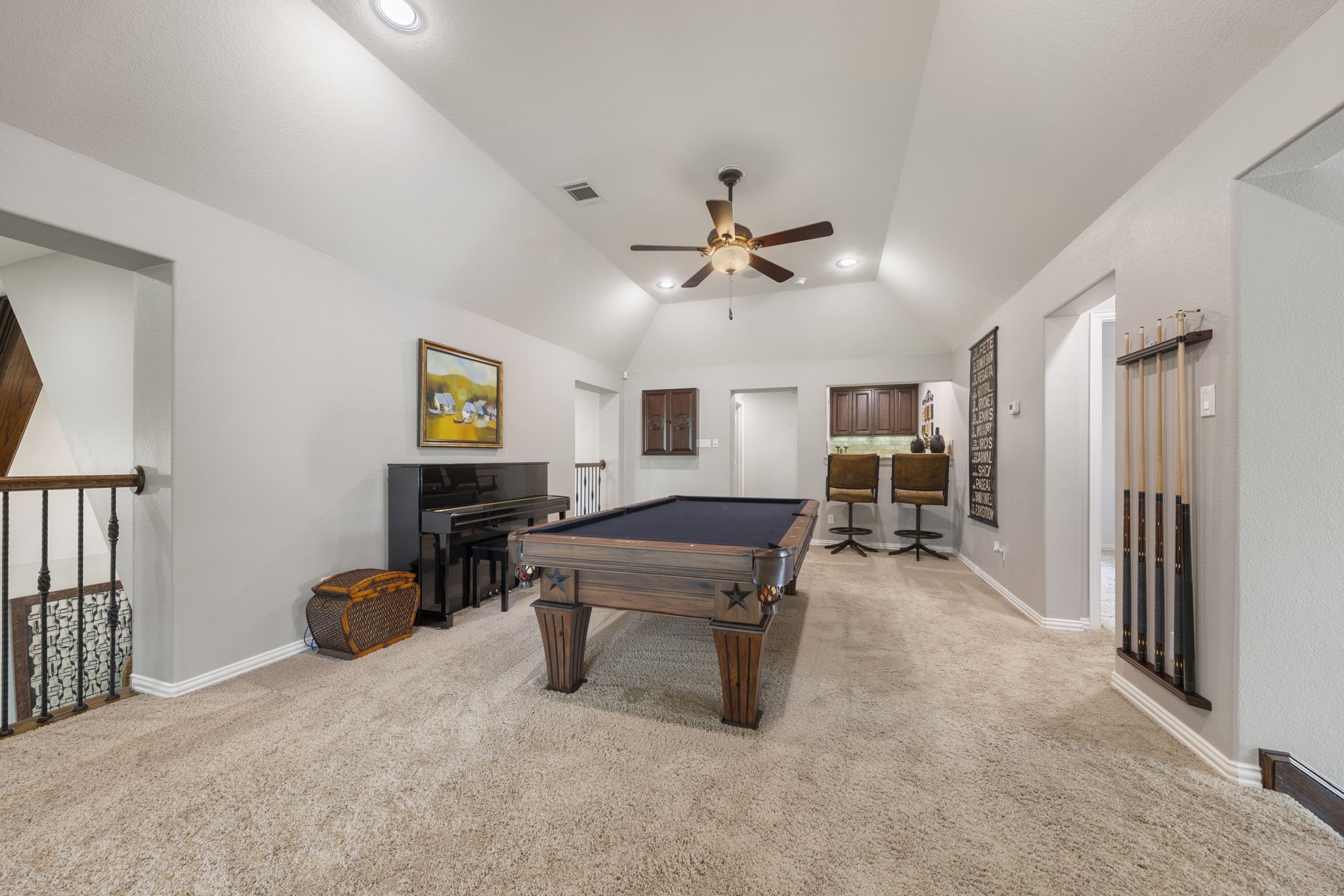 22 Marin Creek Place Spring, TX 77389 - Photo 26 of 38 Impressive game room with a tray ceiling and pool table, offering views over the family room below and complemented by a sophisticated wet bar—an ideal setting for entertaining and leisure.