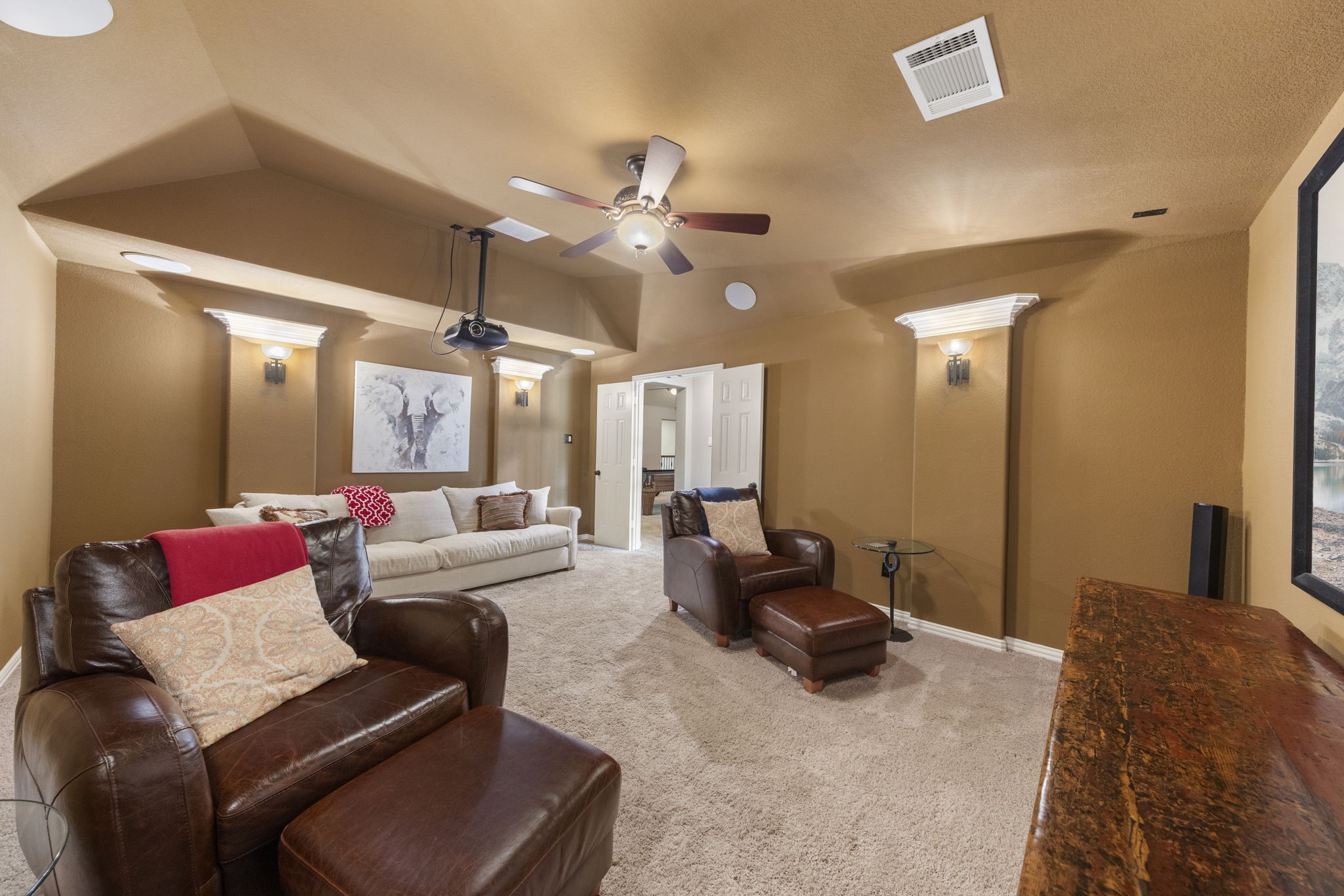 22 Marin Creek Place Spring, TX 77389 - Photo 27 of 38 Private media room designed for immersive movie nights, featuring projector setup, tiered-style layout, and warm theater-inspired ambiance.