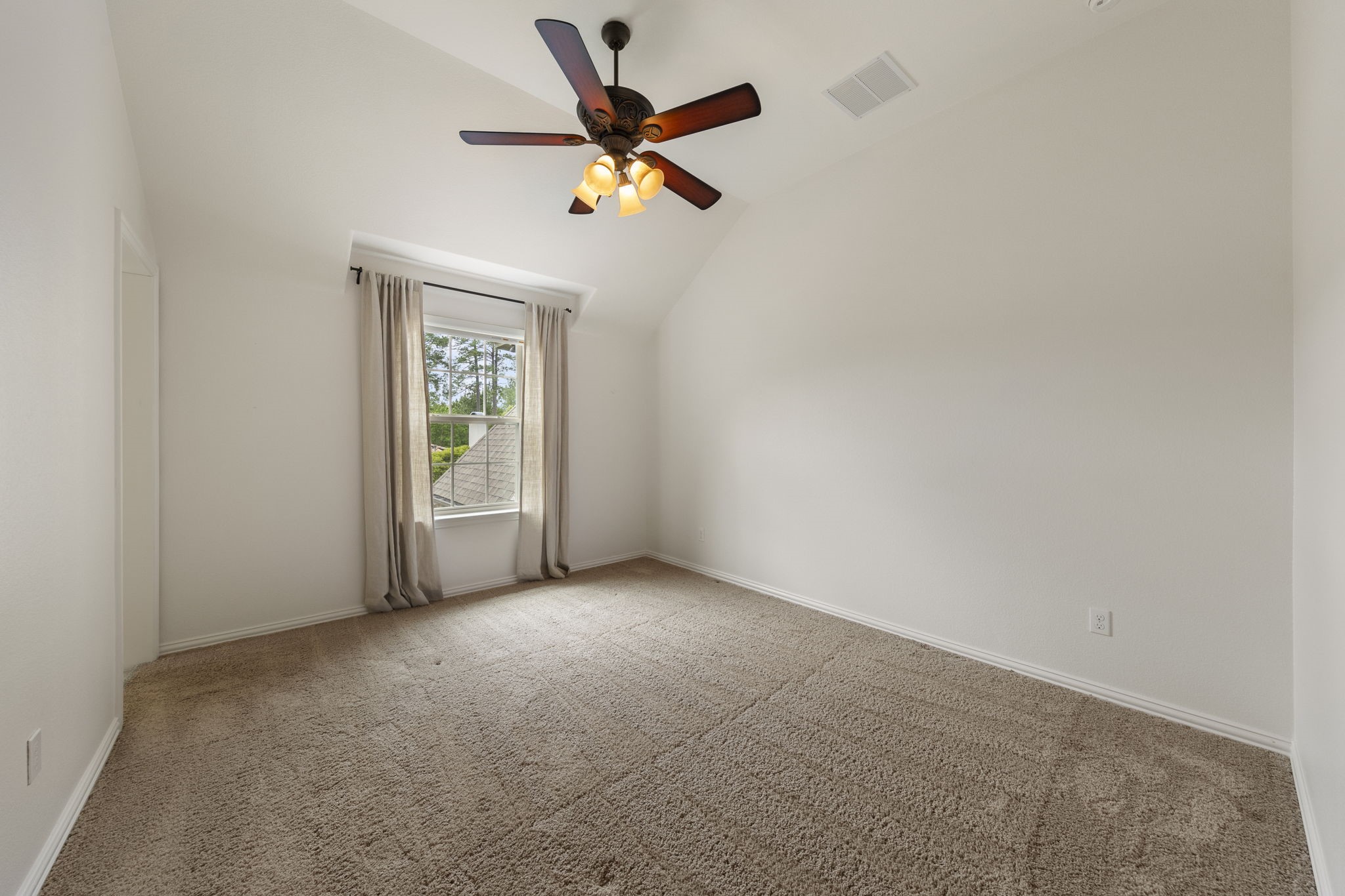 22 Marin Creek Place Spring, TX 77389 - Photo 28 of 38 Light-filled secondary bedroom featuring vaulted ceilings and soft natural light, creating a comfortable and inviting space for guests or family.
