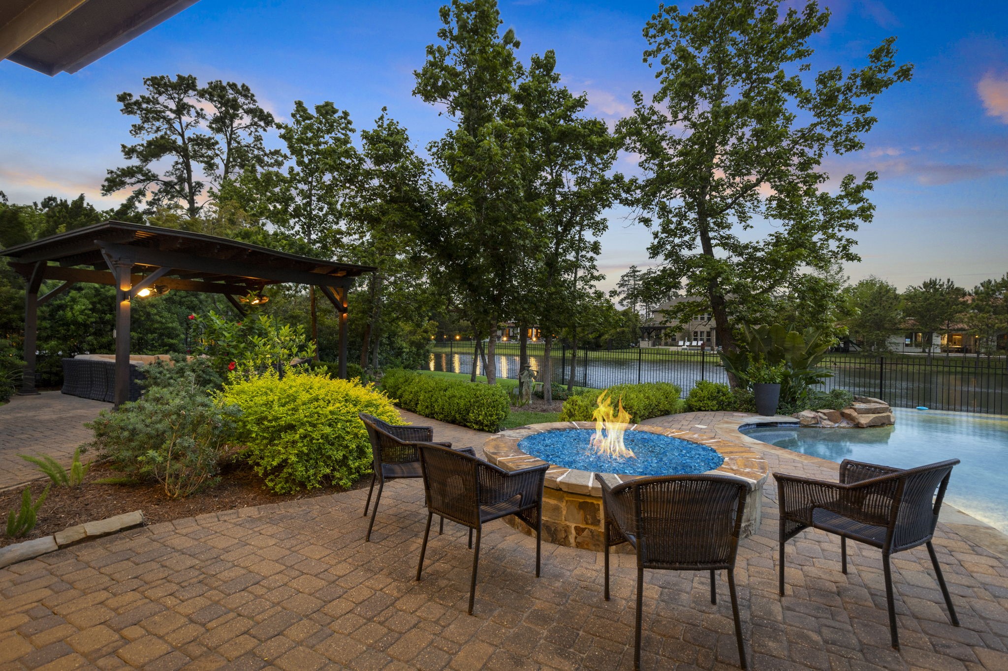 22 Marin Creek Place Spring, TX 77389 - Photo 30 of 38 Inviting fire pit lounge set beside the pool with peaceful views of Lake Paloma. Beautifully landscaped patio creates a perfect setting for evening gatherings.
