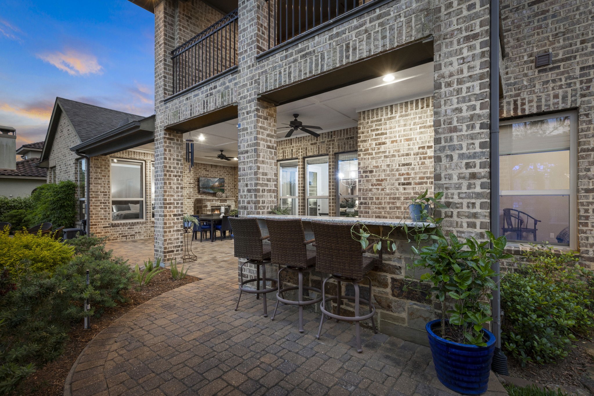 22 Marin Creek Place Spring, TX 77389 - Photo 32 of 38 Outdoor entertaining space with built-in bar seating, complemented by an upper balcony and classic brick architecture that creates a welcoming backyard retreat.