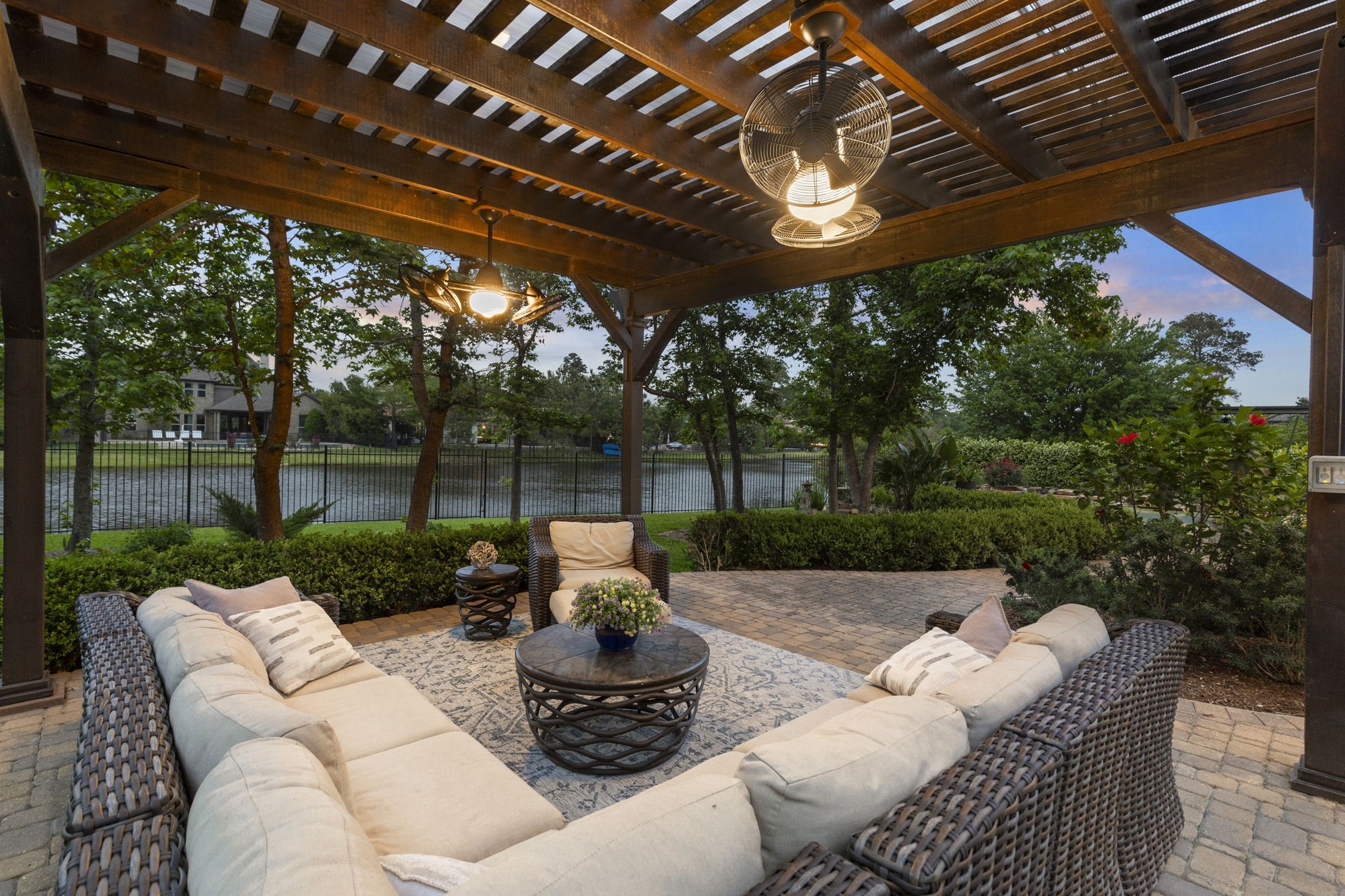 22 Marin Creek Place Spring, TX 77389 - Photo 33 of 38 Covered pergola-style patio with ceiling fans and comfortable seating overlooking serene views of Lake Paloma. A perfect setting for relaxing or entertaining outdoors.