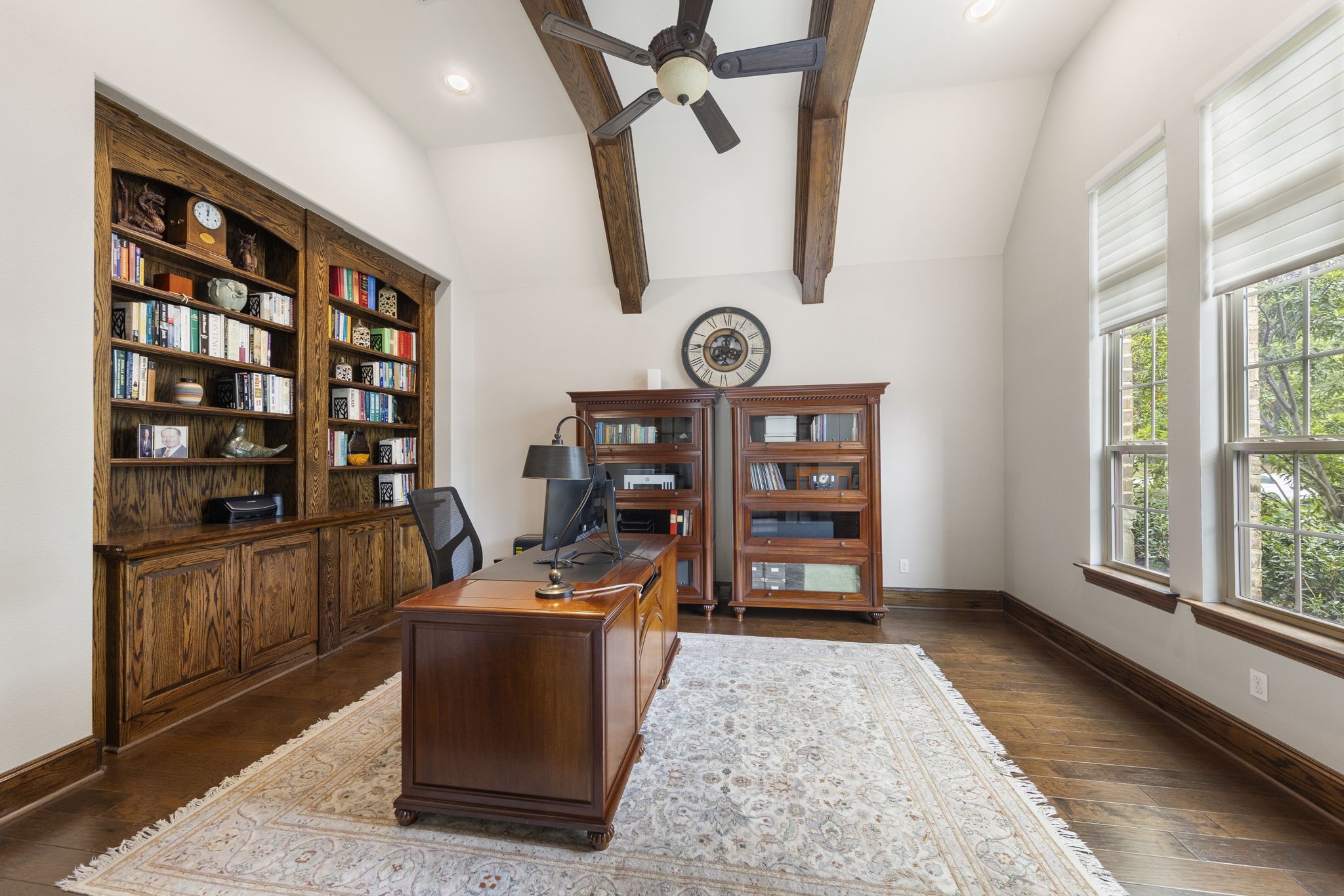 22 Marin Creek Place Spring, TX 77389 - Photo 8 of 38 Distinguished private study with custom wood built-ins, an exposed beam ceiling, and abundant natural light, creating a warm and refined space for a home office or personal library.
