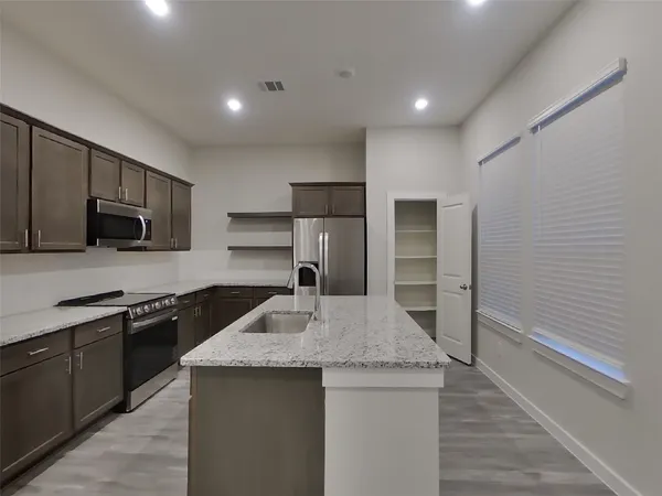 a kitchen with kitchen island a sink stainless steel appliances and cabinets