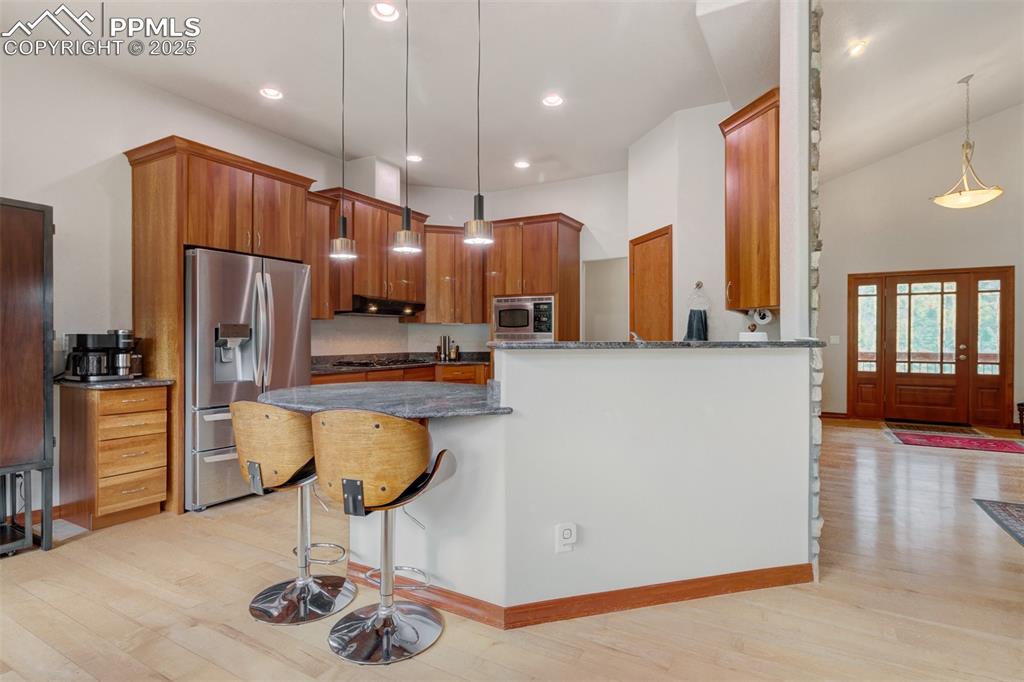 6104 Coffee Pot Road Manitou Springs, CO 80829 - Photo 11 of 49 a kitchen with stainless steel appliances kitchen island granite countertop a refrigerator a stove and a sink