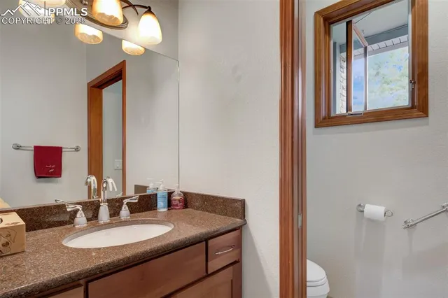 a bathroom with a granite countertop sink and a mirror