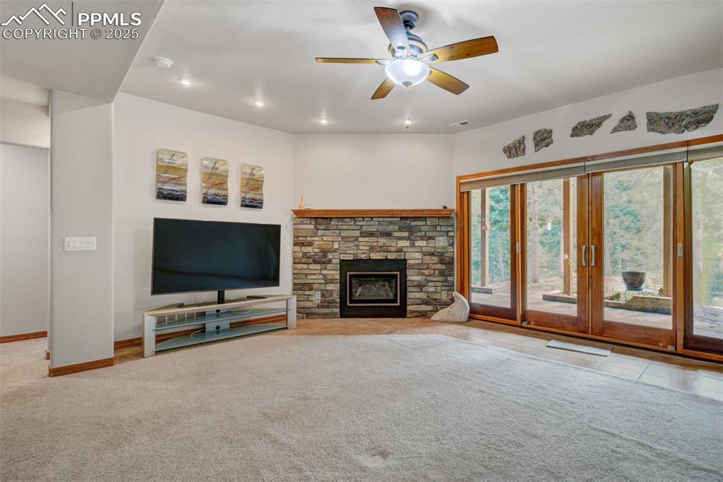6104 Coffee Pot Road Manitou Springs, CO 80829 - Photo 25 of 49 a view of a livingroom with a fireplace a ceiling fan and windows