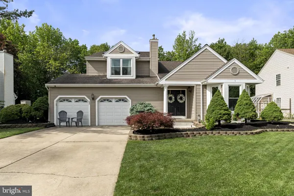 a front view of a house with a garden and plants