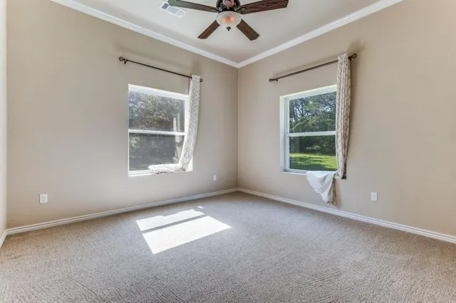 an empty room with a window and ceiling fan