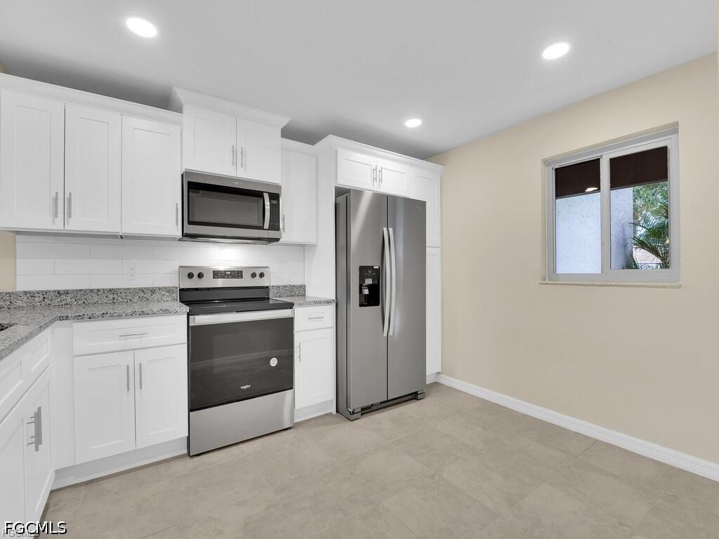 16560 Partridge Place Road, Unit 101 Fort Myers, FL 33908 - Photo 2 of 27 a kitchen with stainless steel appliances a refrigerator stove microwave and sink