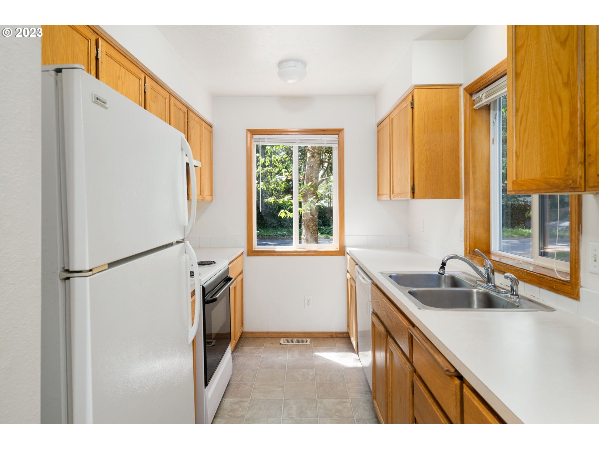 12315 Southeast Boise Street Portland, OR 97236 - Photo 11 of 23 a kitchen with stainless steel appliances a refrigerator sink and cabinets