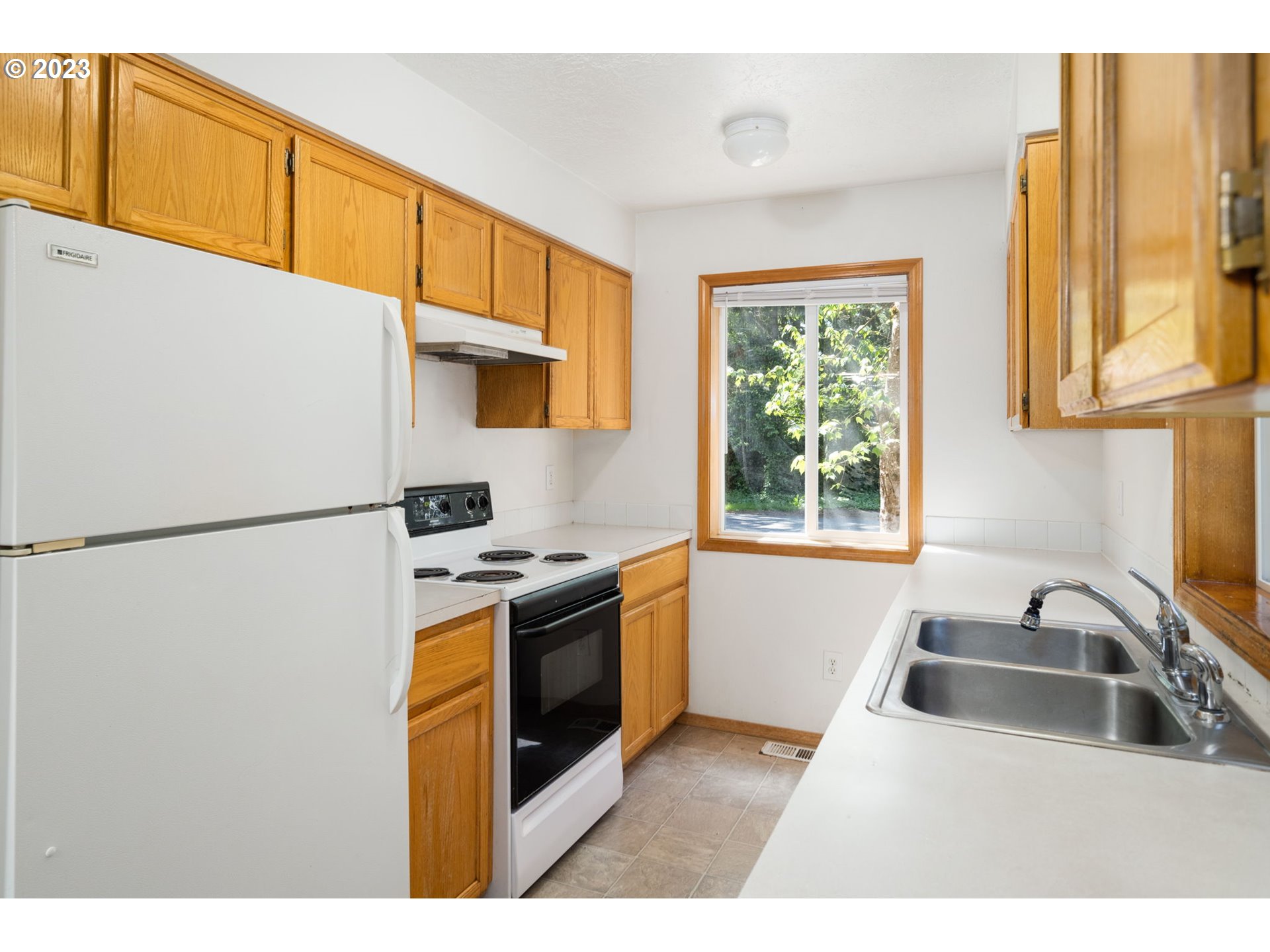 12315 Southeast Boise Street Portland, OR 97236 - Photo 12 of 23 a kitchen with stainless steel appliances granite countertop a refrigerator a sink a stove and a microwave