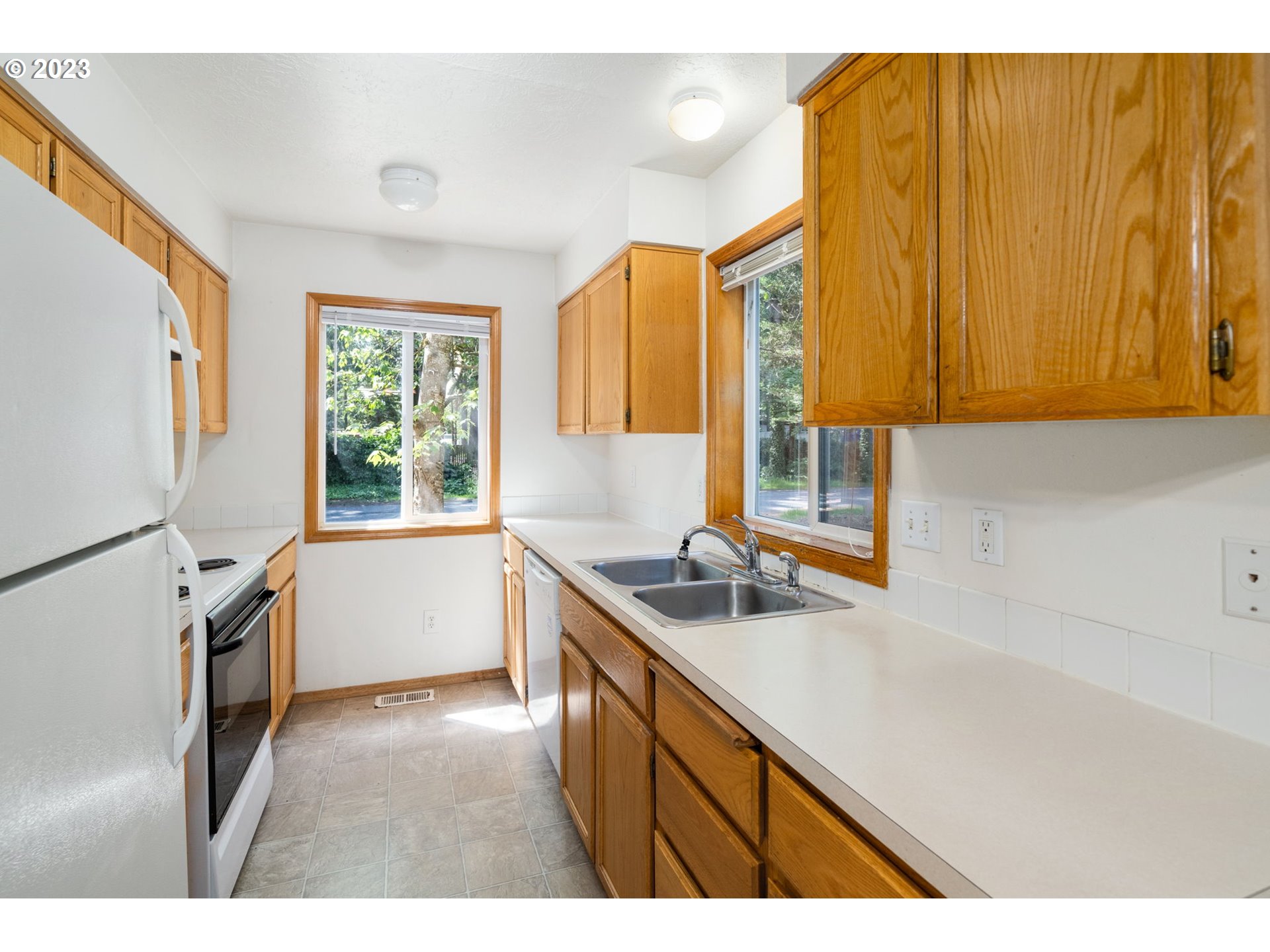 12315 Southeast Boise Street Portland, OR 97236 - Photo 10 of 23 a kitchen with sink cabinets and window