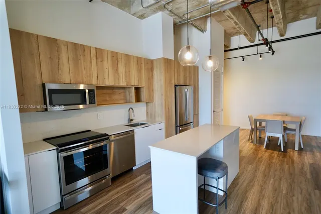 a kitchen with a sink a microwave a stove and refrigerator