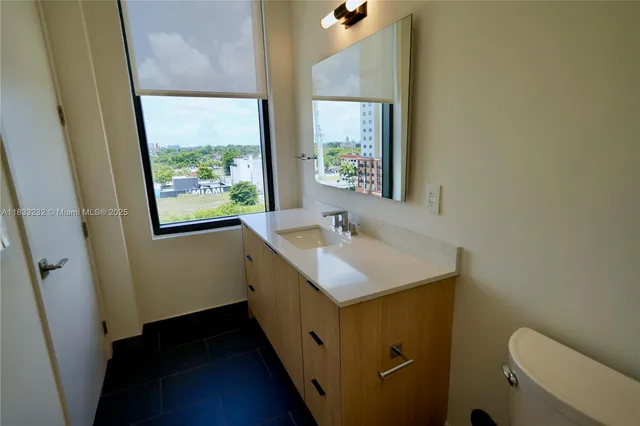 a bathroom with a sink toilet and a window