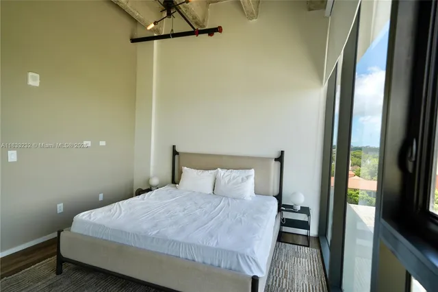 a bedroom with a bed and a flat tv screen on a dresser