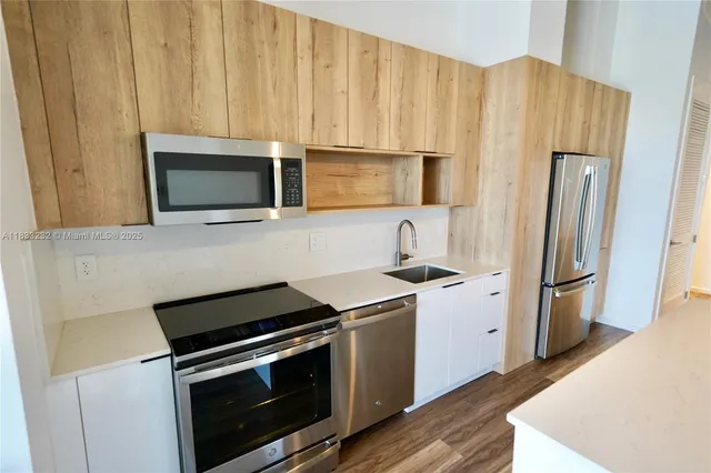 a kitchen with granite countertop a stove microwave and refrigerator