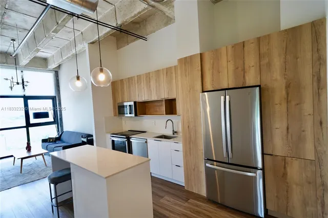 a kitchen with stainless steel appliances a refrigerator and a stove top oven