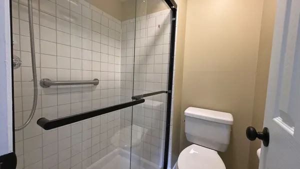 a white toilet sitting next to a shower