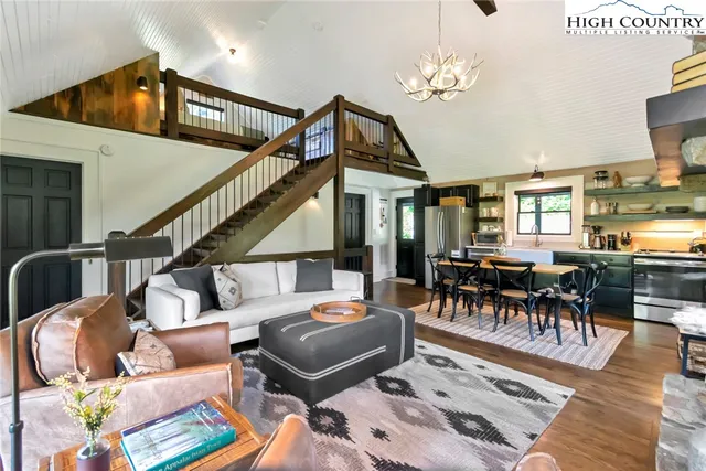 a living room with furniture and a dining table with wooden floor
