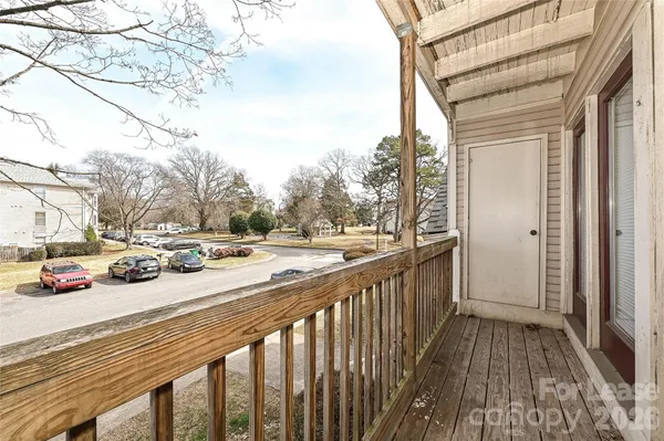 a view of a balcony with wooden floor and fence