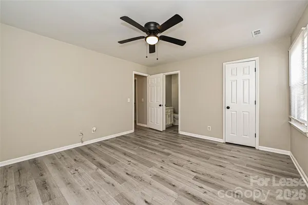 an empty room with wooden floor and ceiling fan