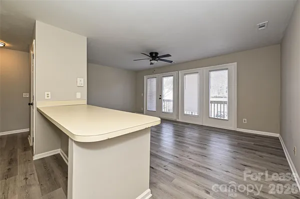 a very nice looking room with wooden floor and a ceiling fan
