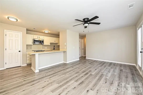 a view of a kitchen with wooden floor and a kitchen space