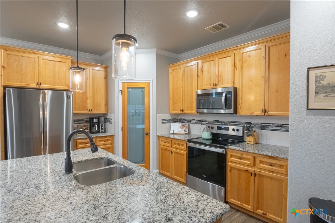7909 McCulloch Road Temple, TX 76502 - Photo 17 of 46 a kitchen with stainless steel appliances granite countertop a stove refrigerator sink and dishwasher