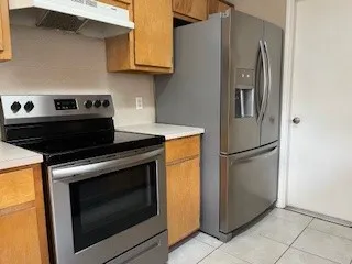 a kitchen with stainless steel appliances granite countertop a refrigerator stove and microwave