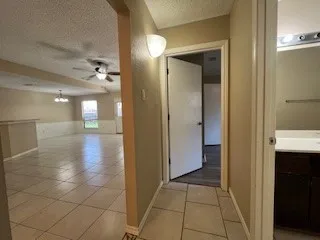 a view of hallway with a bathroom and a glass door shower