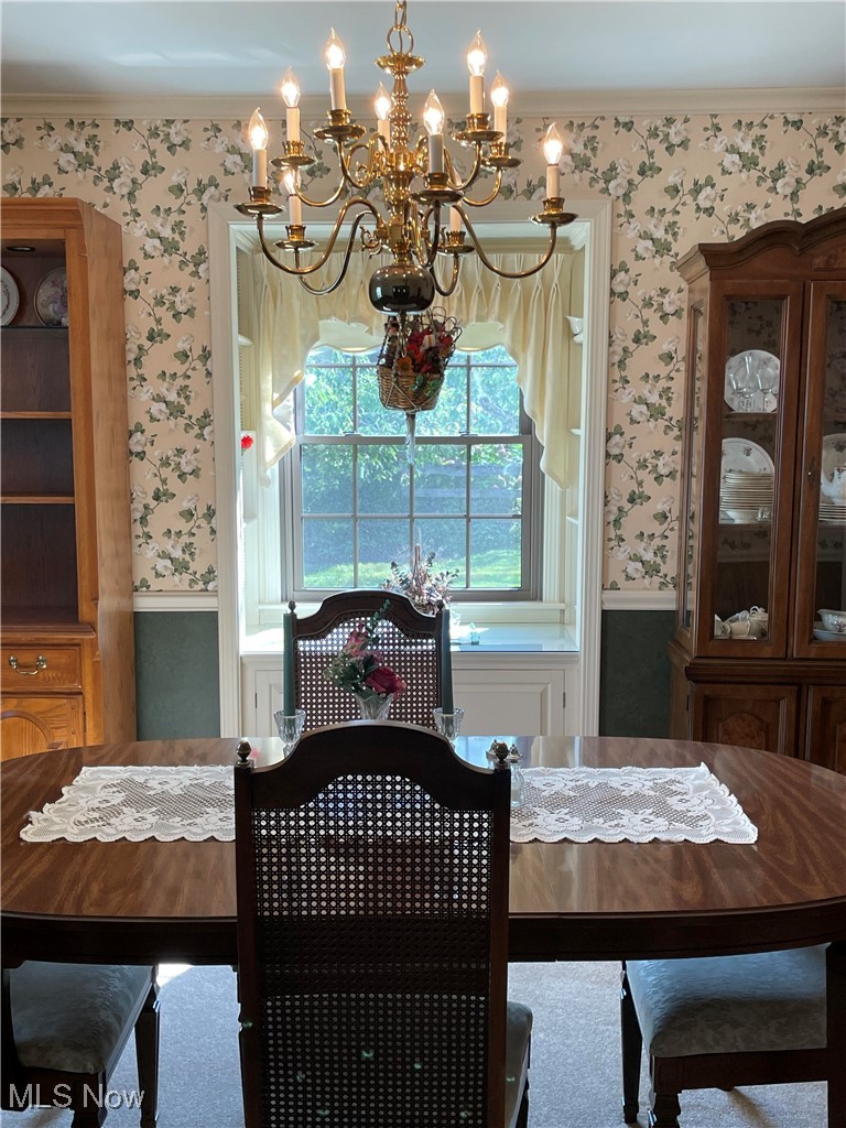 730 Phillips Road Northeast Massillon, OH 44646 - Photo 13 of 27 Carpeted dining space featuring crown molding and a notable chandelier