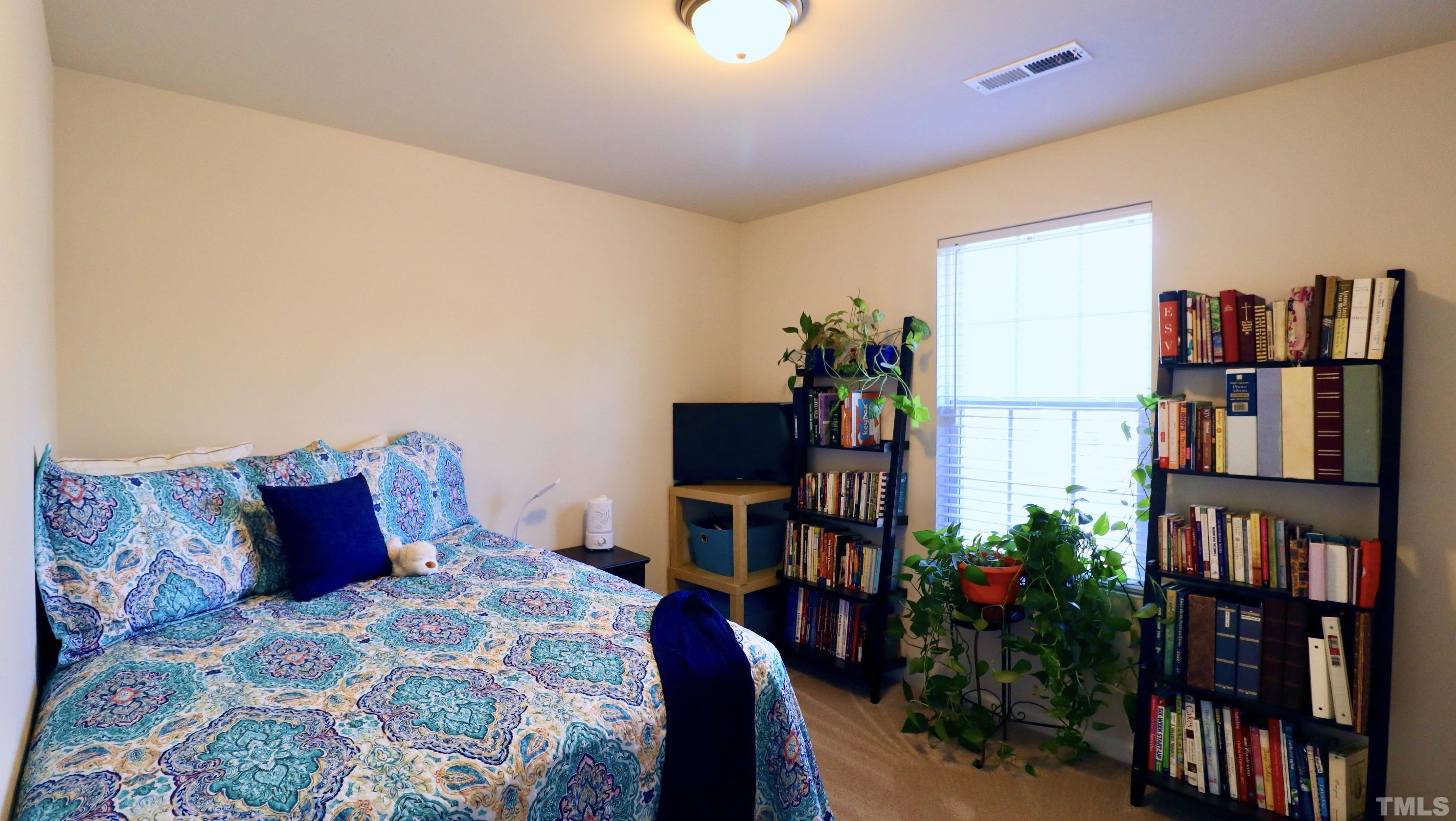9914 Nugget Road Spring Hope, NC 27882 - Photo 5 of 10 a bedroom with a bed and a book shelf