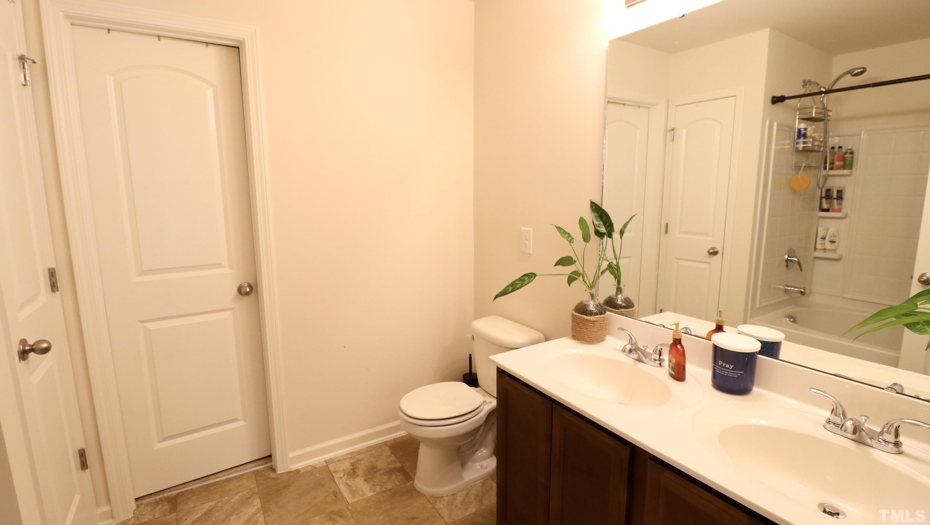 9914 Nugget Road Spring Hope, NC 27882 - Photo 6 of 10 a bathroom with a granite countertop sink a toilet and a mirror