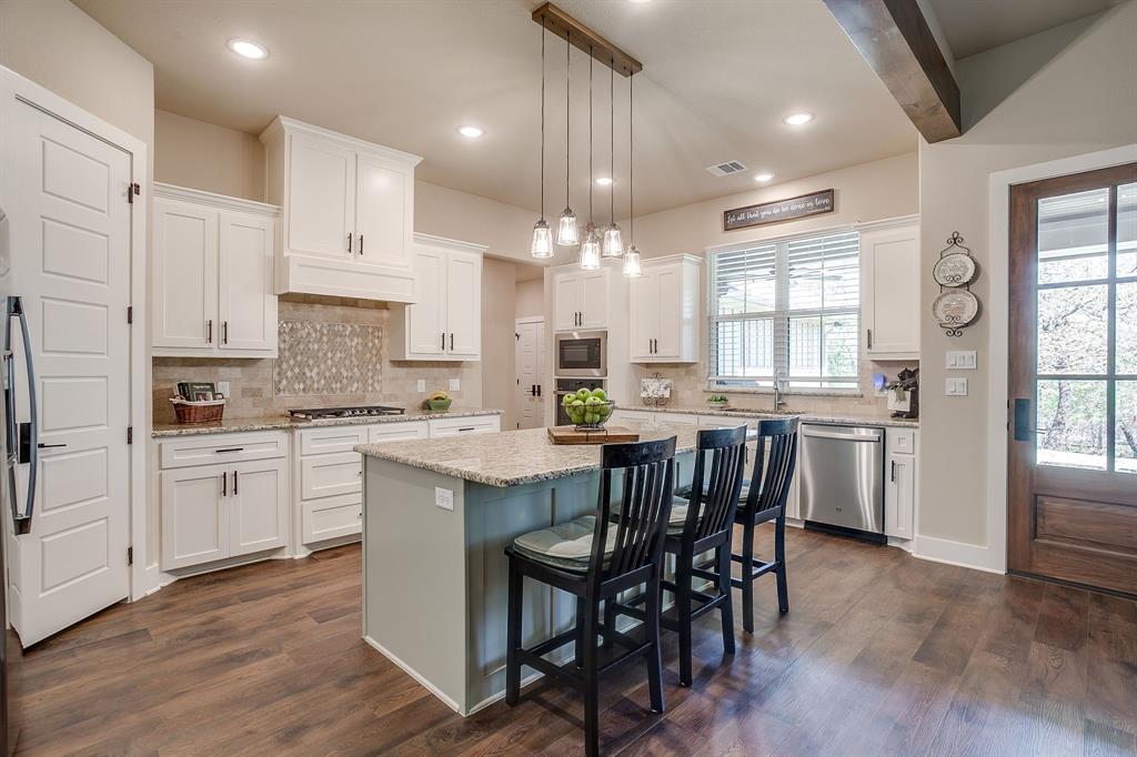 322 Mountainview Court Sunset, TX 76270 - Photo 14 of 40 a kitchen with stainless steel appliances granite countertop a white cabinets and wooden floor