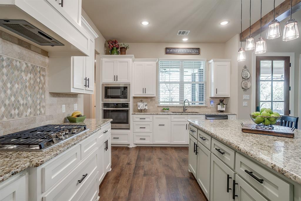 322 Mountainview Court Sunset, TX 76270 - Photo 18 of 40 a kitchen with granite countertop a sink stove cabinets and stainless steel appliances
