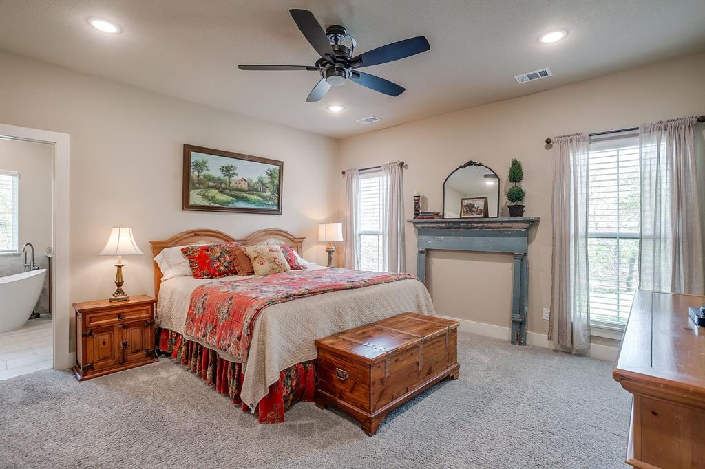 322 Mountainview Court Sunset, TX 76270 - Photo 22 of 40 a spacious bedroom with a bed and a chandelier