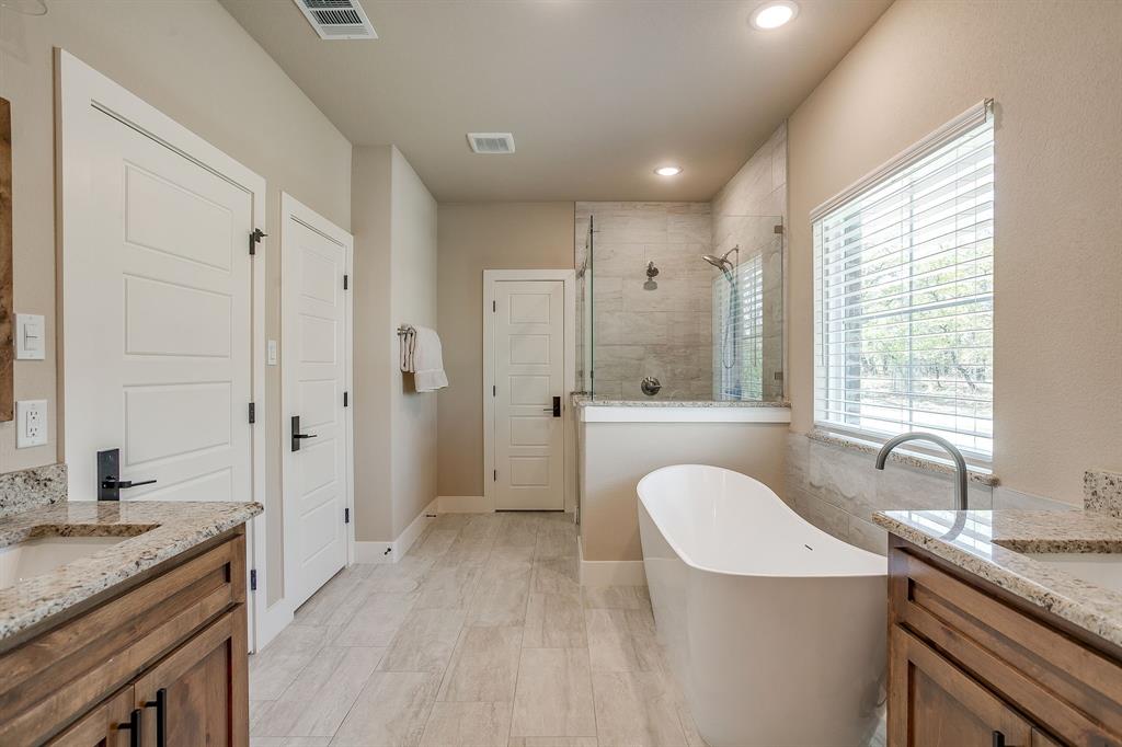 322 Mountainview Court Sunset, TX 76270 - Photo 26 of 40 a spacious bathroom with a granite countertop sink a mirror a bathtub and shower