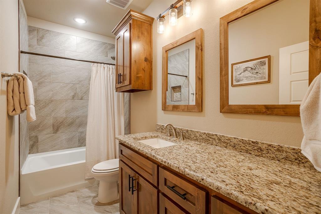 322 Mountainview Court Sunset, TX 76270 - Photo 29 of 40 a bathroom with a granite countertop sink a toilet and shower