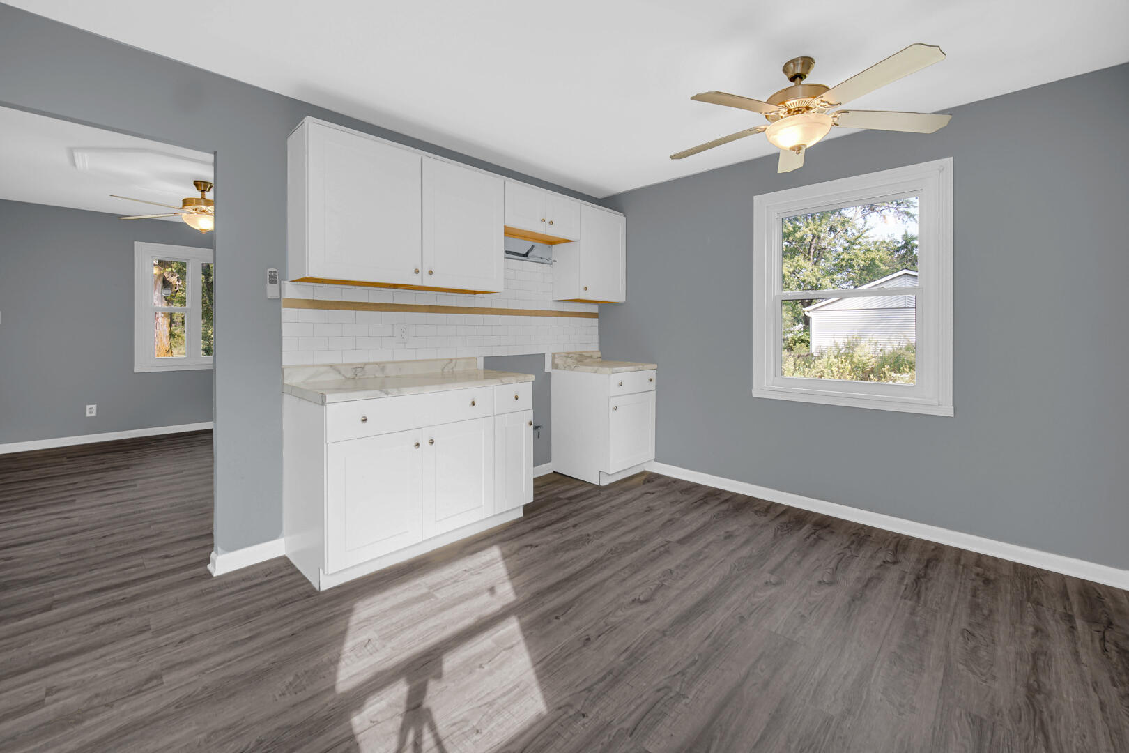 1159 Fayette Street Gary, IN 46403 - Photo 4 of 19 an empty room with wooden floor chandelier fan and windows