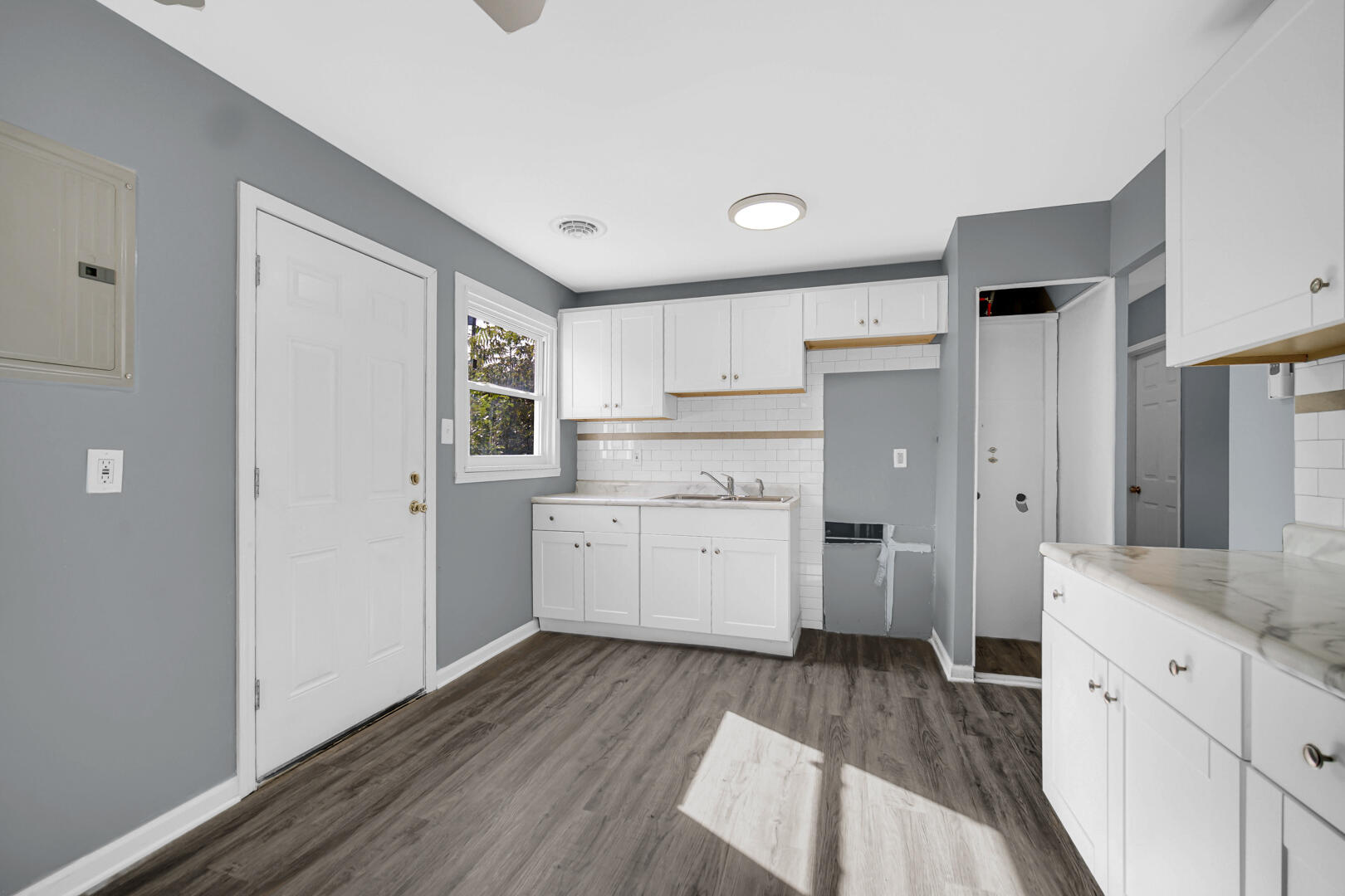 1159 Fayette Street Gary, IN 46403 - Photo 6 of 19 a kitchen with cabinets wooden floor and stainless steel appliances