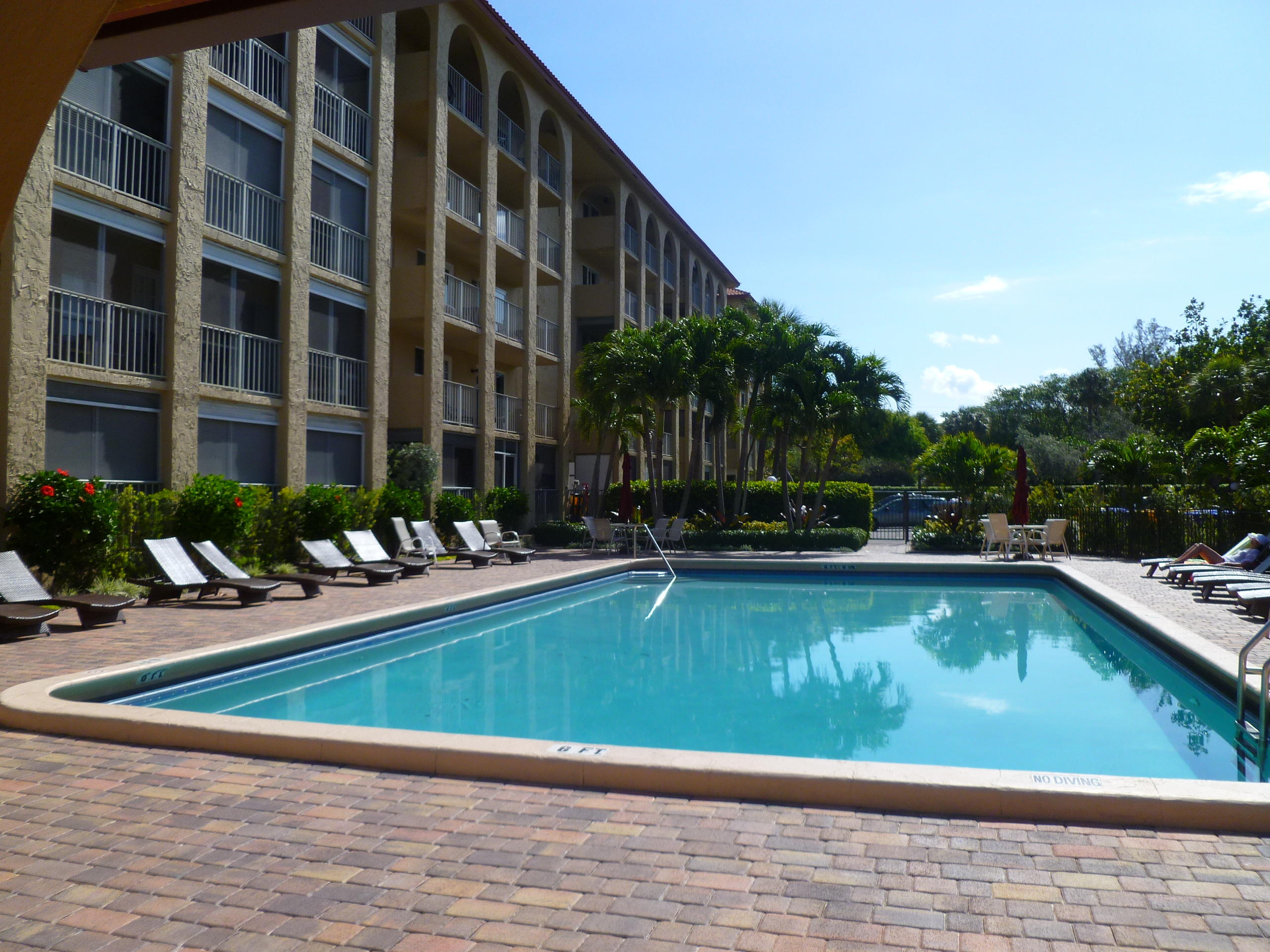 950 Ponce De Leon Road, Unit 104 Boca Raton, FL 33432 - Photo 6 of 33 a view of swimming pool with outdoor seating and house in the background