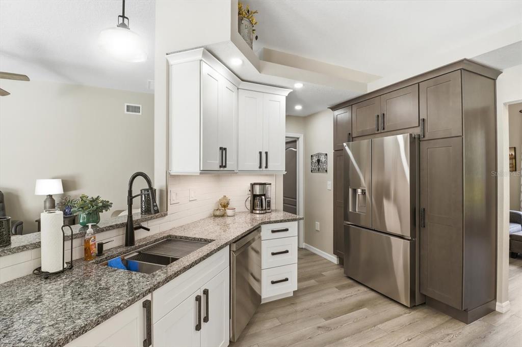16 Calendula Court Homosassa, FL 34446 - Photo 15 of 50 a kitchen with stainless steel appliances granite countertop a refrigerator sink and white cabinets
