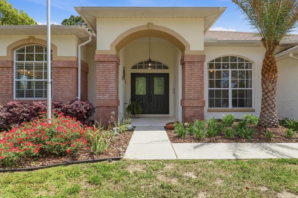 16 Calendula Court Homosassa, FL 34446 - Photo 6 of 50 a view of a house with potted plants and a large tree